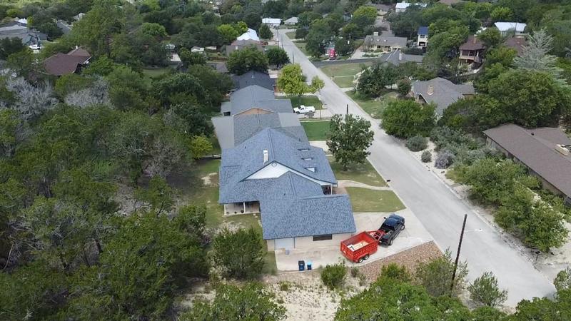 Drone view of a blue-gray shingle roof on a neighborhood home
